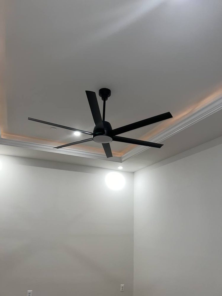 Black ceiling fan with a light mounted on a tray ceiling