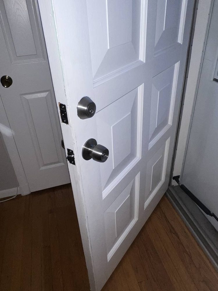 White six-panel door with a new round knob and deadbolt