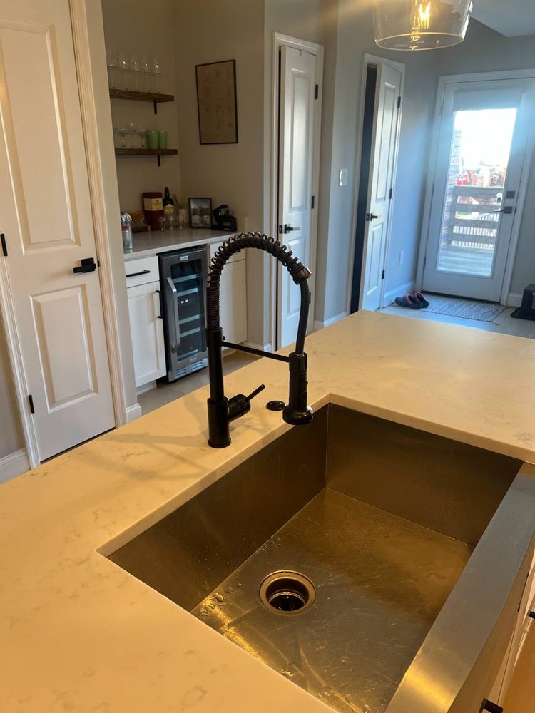 Undermount kitchen sink with a black pull-down faucet in a quartz counter