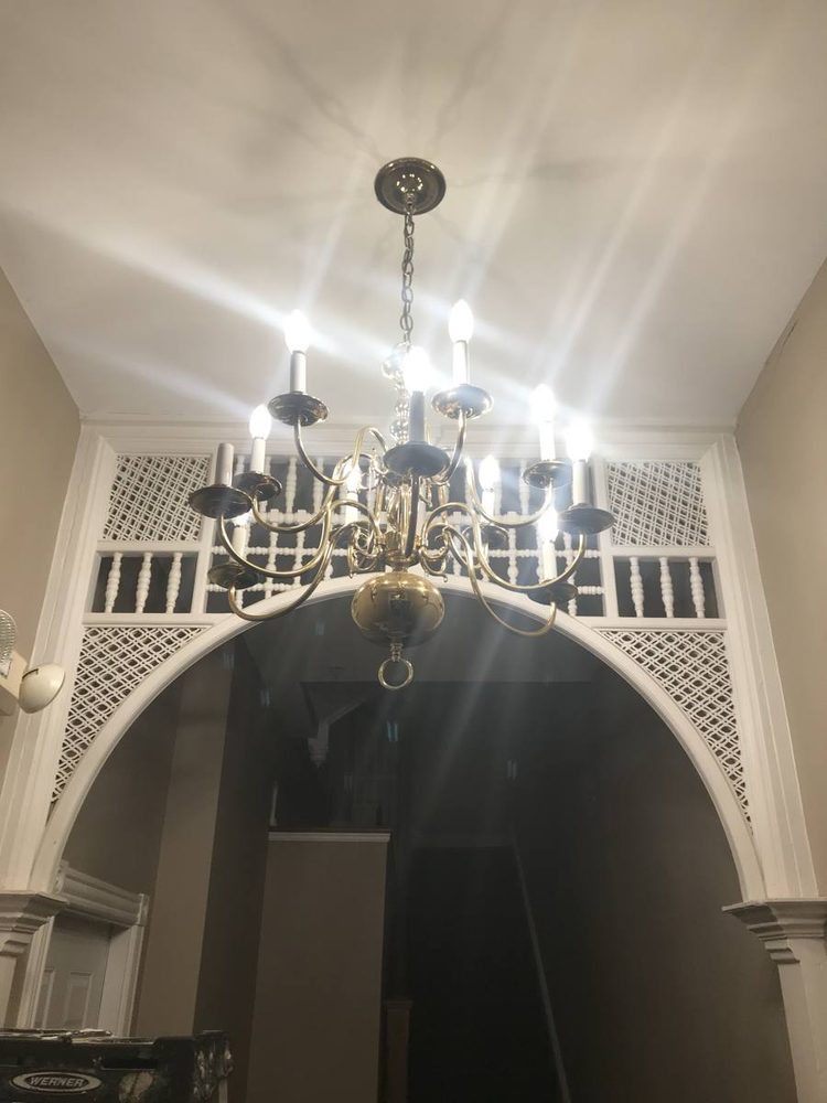 An illuminated chandelier hanging above an arched opening.