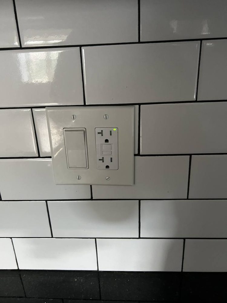 New outlet and rocker switch installed in a subway tile backsplash
