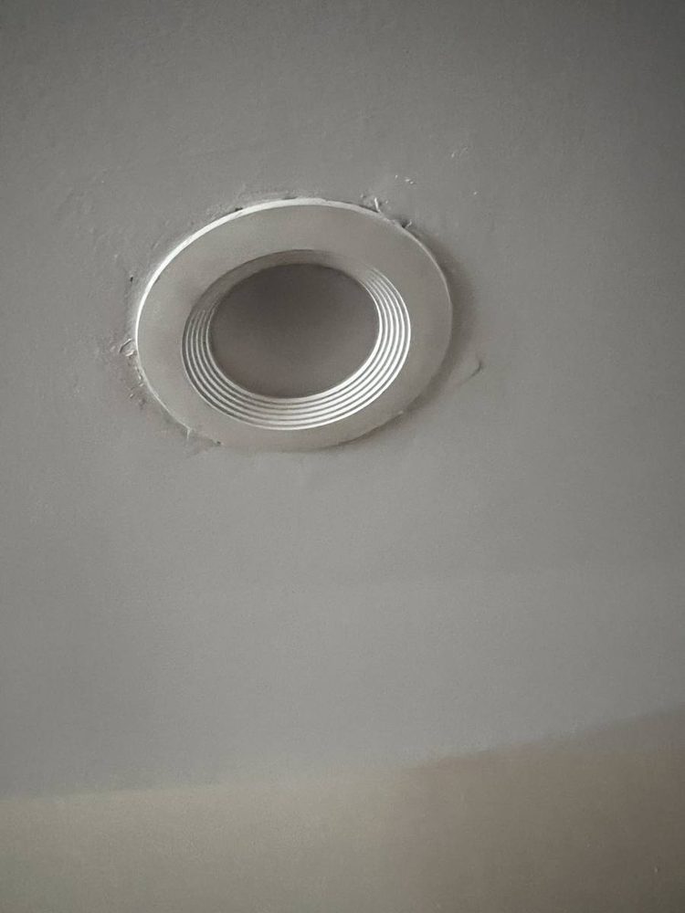 Recessed light with a white baffle trim set into a ceiling
