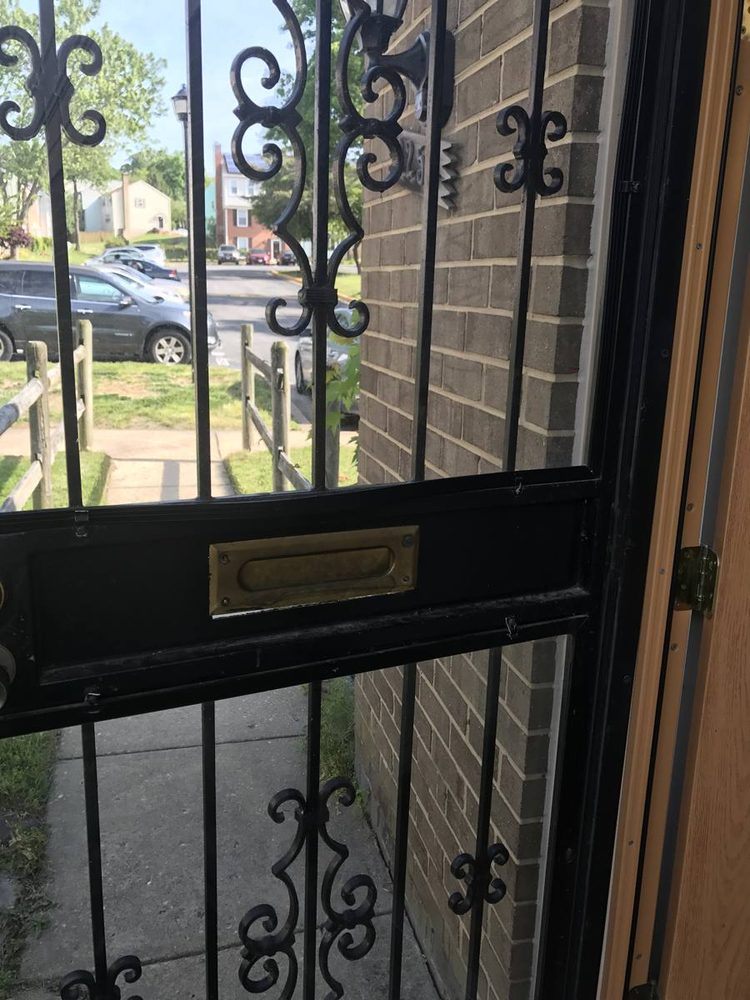 A black outer door with decorative metalwork and a mail slot.