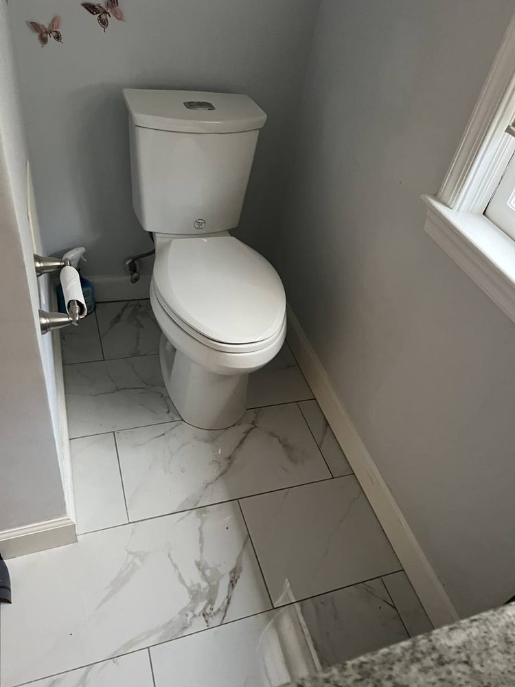 Two-piece toilet installed on a marble tile floor